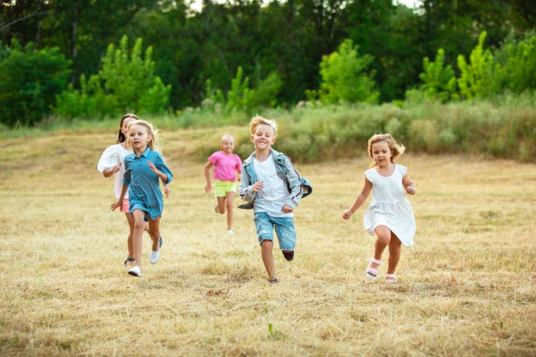 Enfants courant joyeusement dans un pré ensoleillé en été