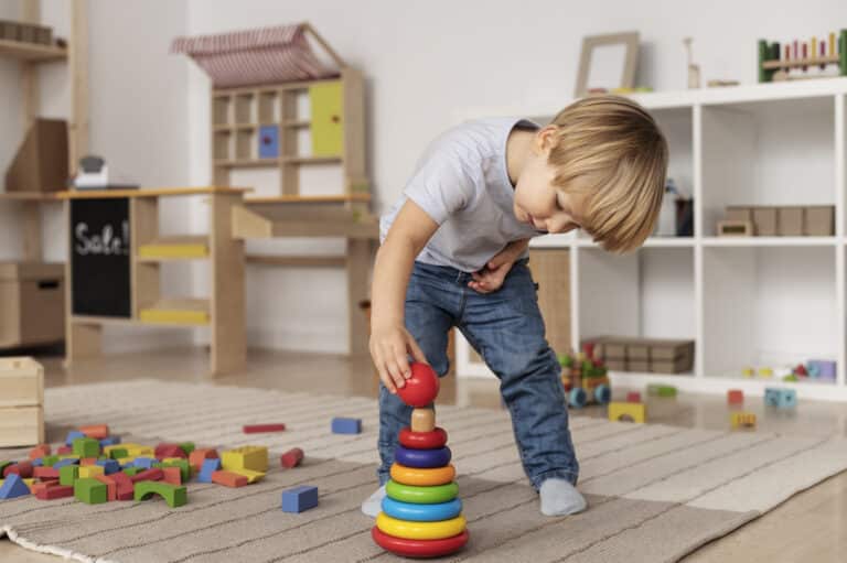 Enfant jouant en sécurité sur le sol avec des jouets en bois